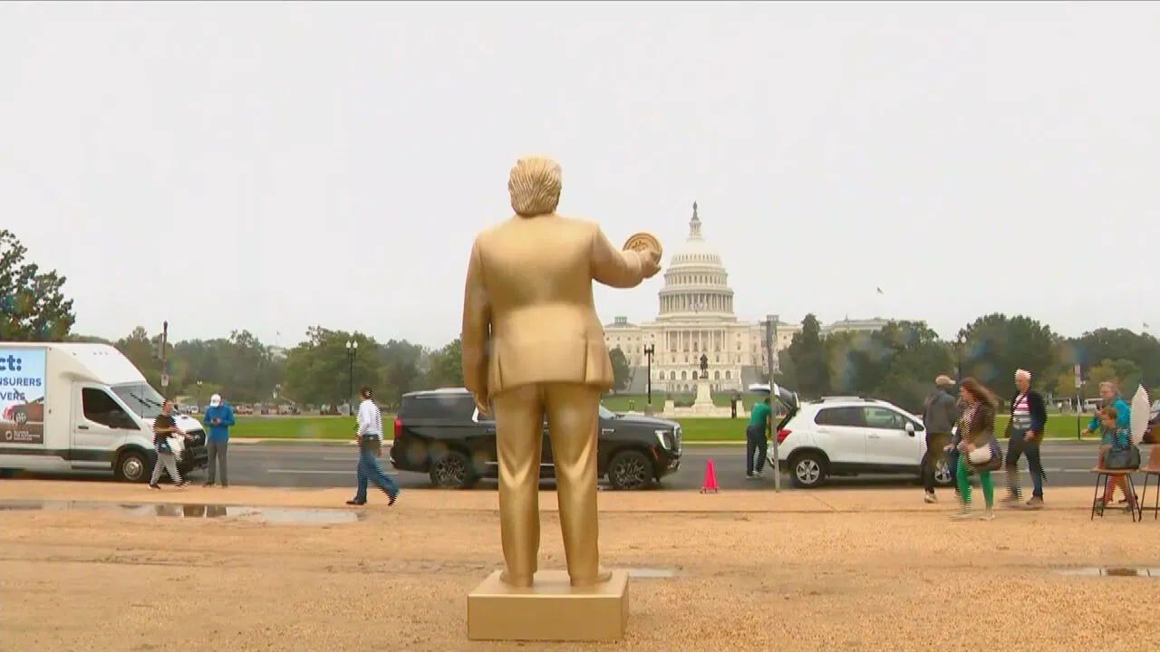 Золотая статуя Трампа с биткойном в руке в центре Вашингтона.