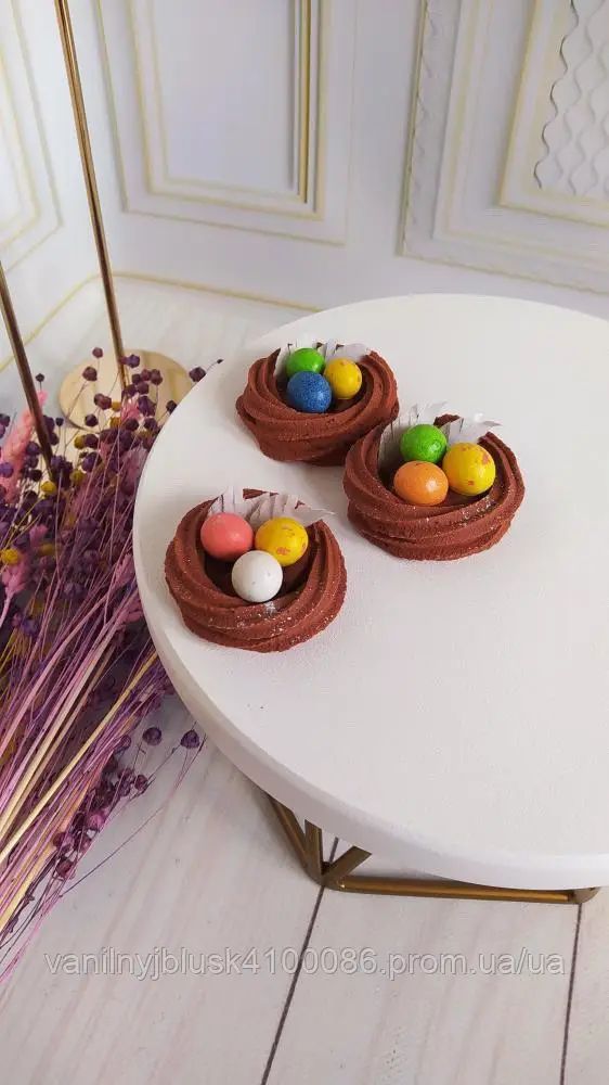 Цукрові крашанки, які лежать в гніздечку з легкого безе