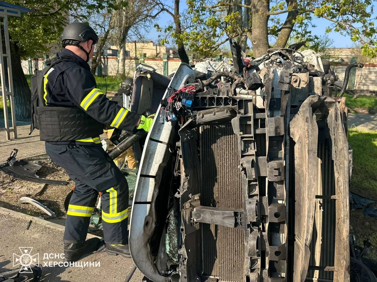 Рятувальники біля атакованої автівки. Фото: ДСНС