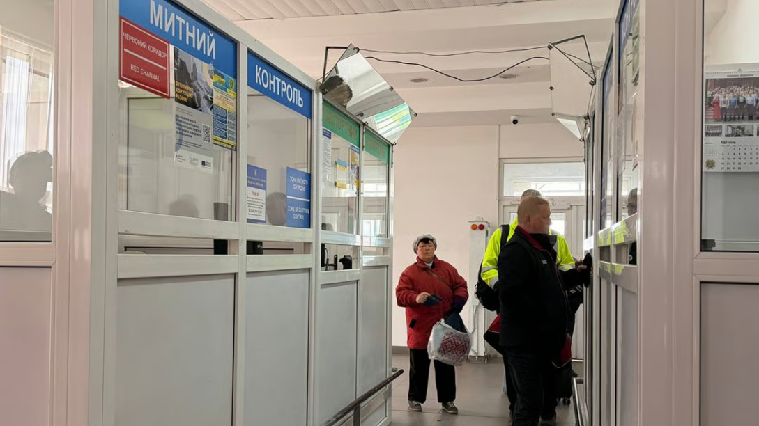 Люди проходять митний контроль