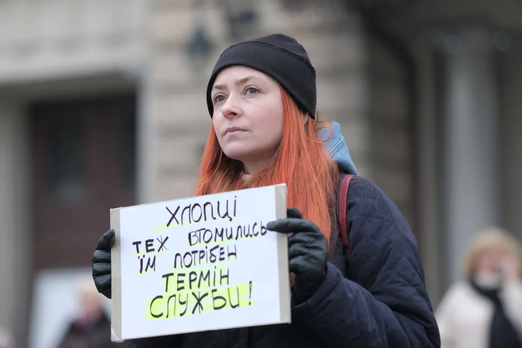 Активист держит баннер с надписью о демобилизации в ВСУ