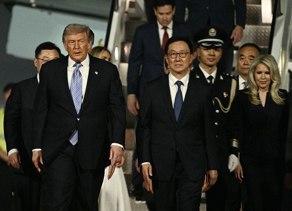 Президент США Дональд Трамп выходит из самолета Air Force One вместе с руководителем протокола Белого дома Моникой Кроули (справа) в сопровождении вице-президента Китая Хань Чжэна по прибытии в Пекинский столичный аэропорт в Пекине 13 мая 2026 года