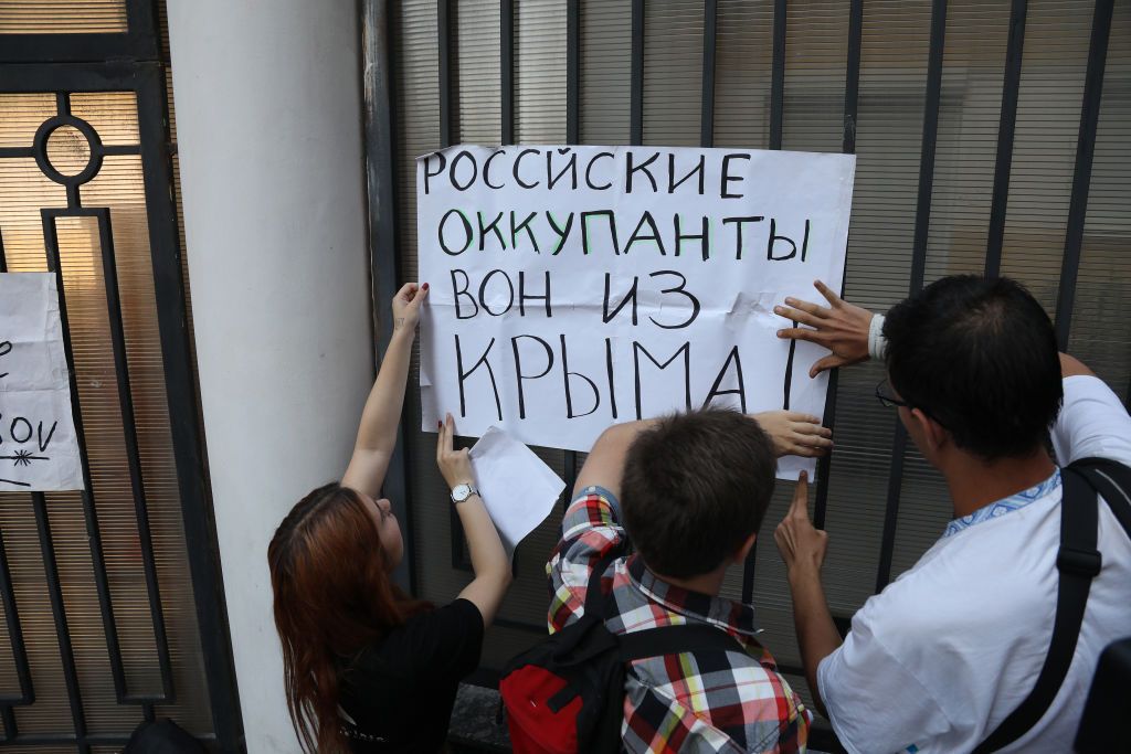Демонстранти вішають плакат протесту з написом «Російський окупант, геть з Криму» на паркані Генерального консульства Російської Федерації Демонстранти вішають плакат протесту з написом «Російський окупант, геть з Криму» на паркані Генерального консульства Російської Федерації