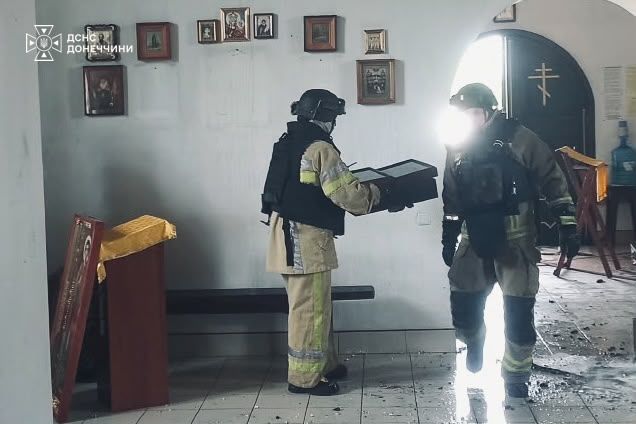 Рятувальники виносять ікони з вогню Рятувальники виносять ікони з вогню
