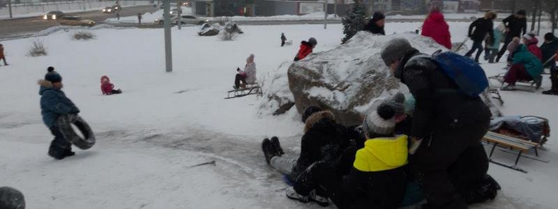 Зимние забавы: в Днепре десятки детей спускаются с импровизированной ледяной горки