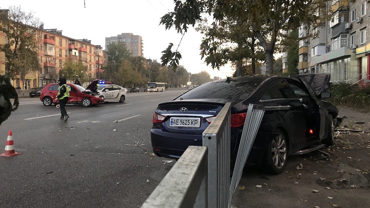 В Днепре на Слобожанском проспекте от удара со Skoda Hyundai вылетел на тротуар, снес забор и врезался в дерево: женщину забрала скорая