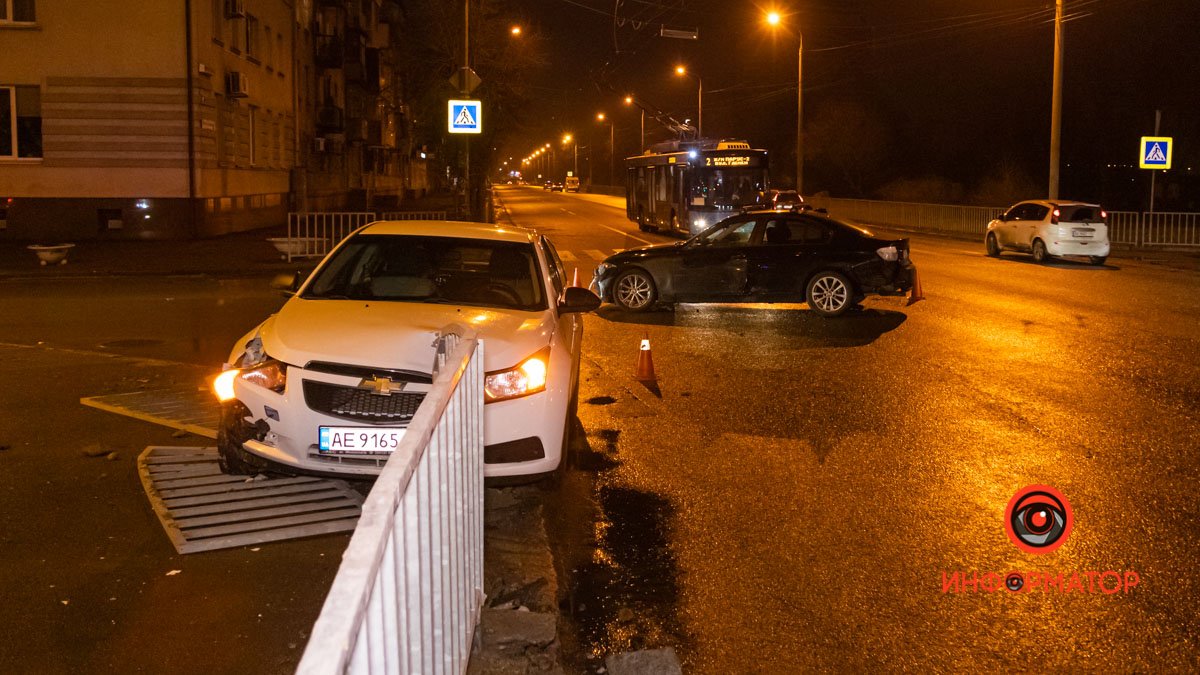 В Днепре на Сичеславской Набережной возле "Поплавка" Chevrolet столкнулся с BMW и влетел в забор