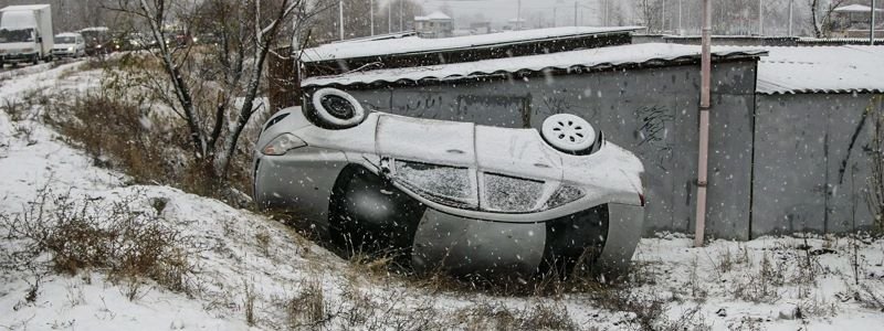 Гололед в Киеве: прохожий доставал водителя и пассажира перевернувшегося Ford
