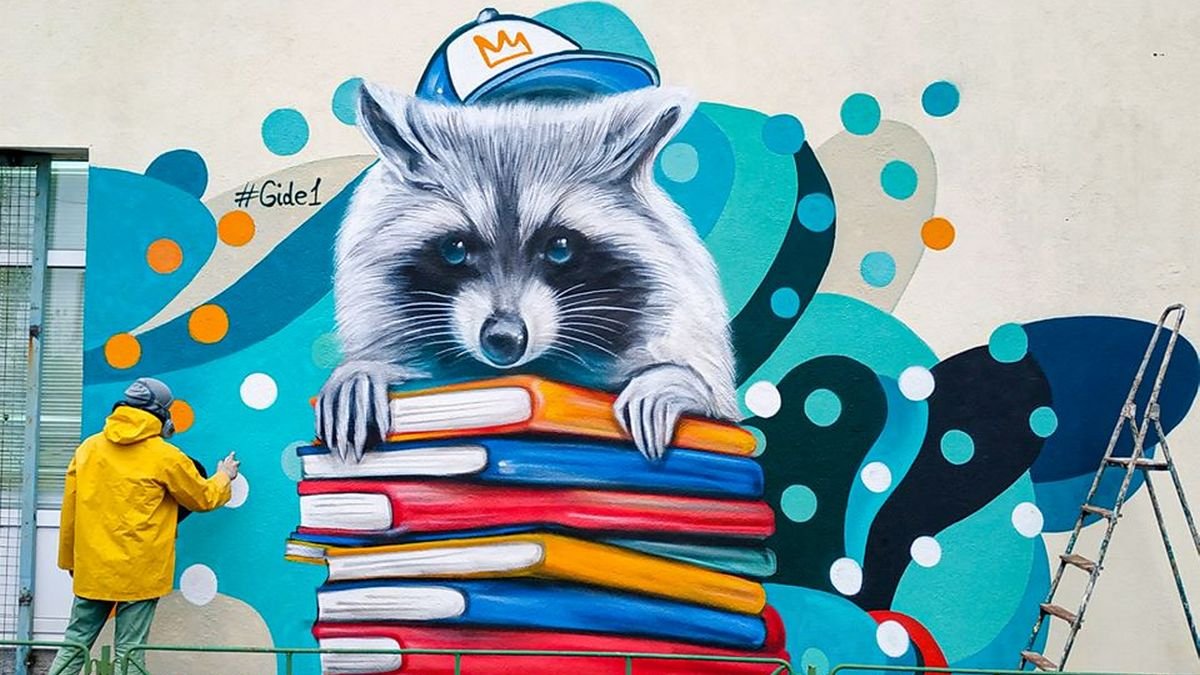В Киеве на Оболони на стене школы поселился енот с учебниками: что означает новый мурал