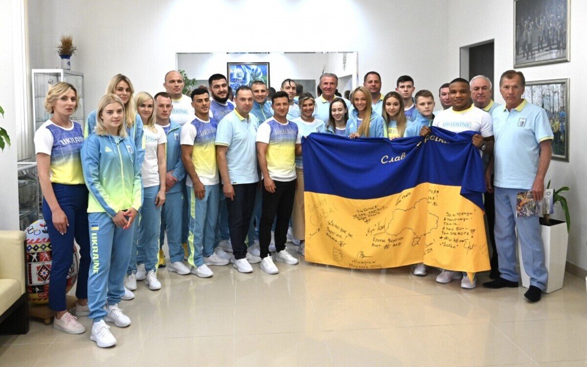 Зеленский подарил украинским спортсменам флаг, подписанный военными в ООС