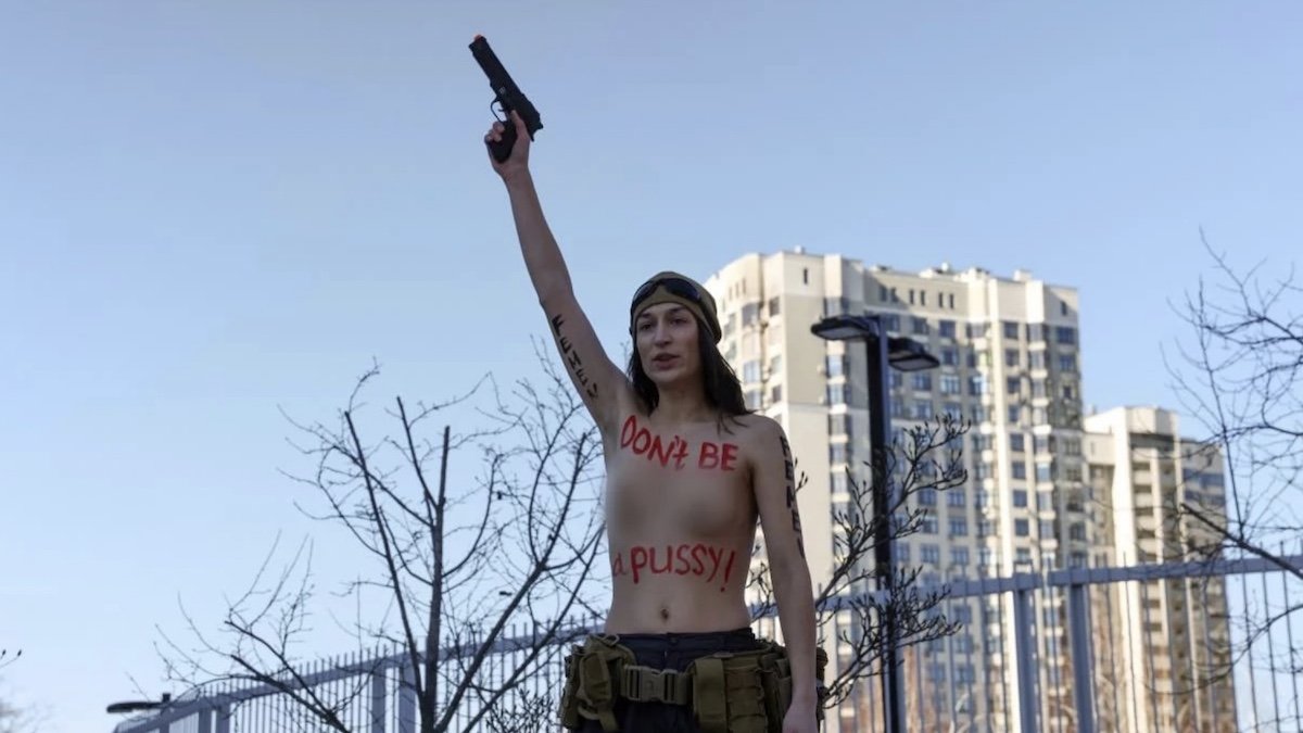 «Не будь киской»: активистка Femen с оружием в руках оголила грудь и высмеяла послов, которые бегут из Украины
