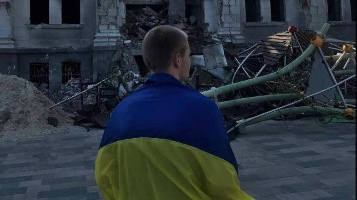 Окупований, та не підкорений: у Маріуполі юнак вийшов на площу розбомбленого Драмтеатру з прапором України